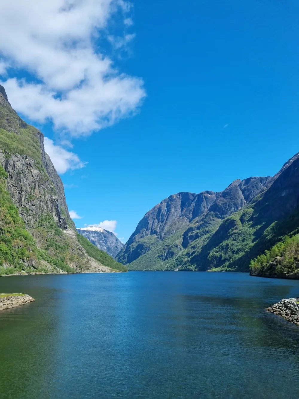 Sügavsinine fjord järskude roheliste mäenõlvade vahel